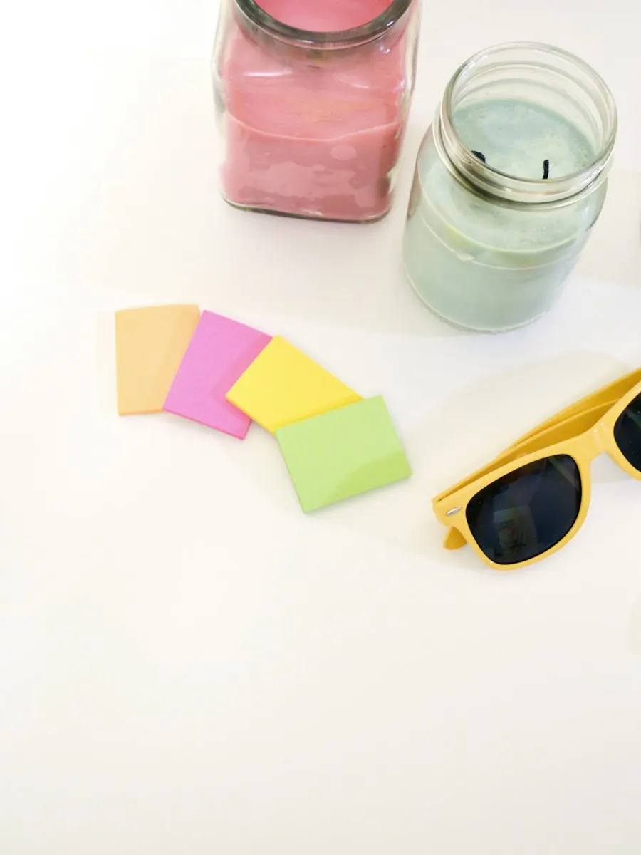 Stillleben mit Kerzen, Haftnotizen und gelber Sonnenbrille